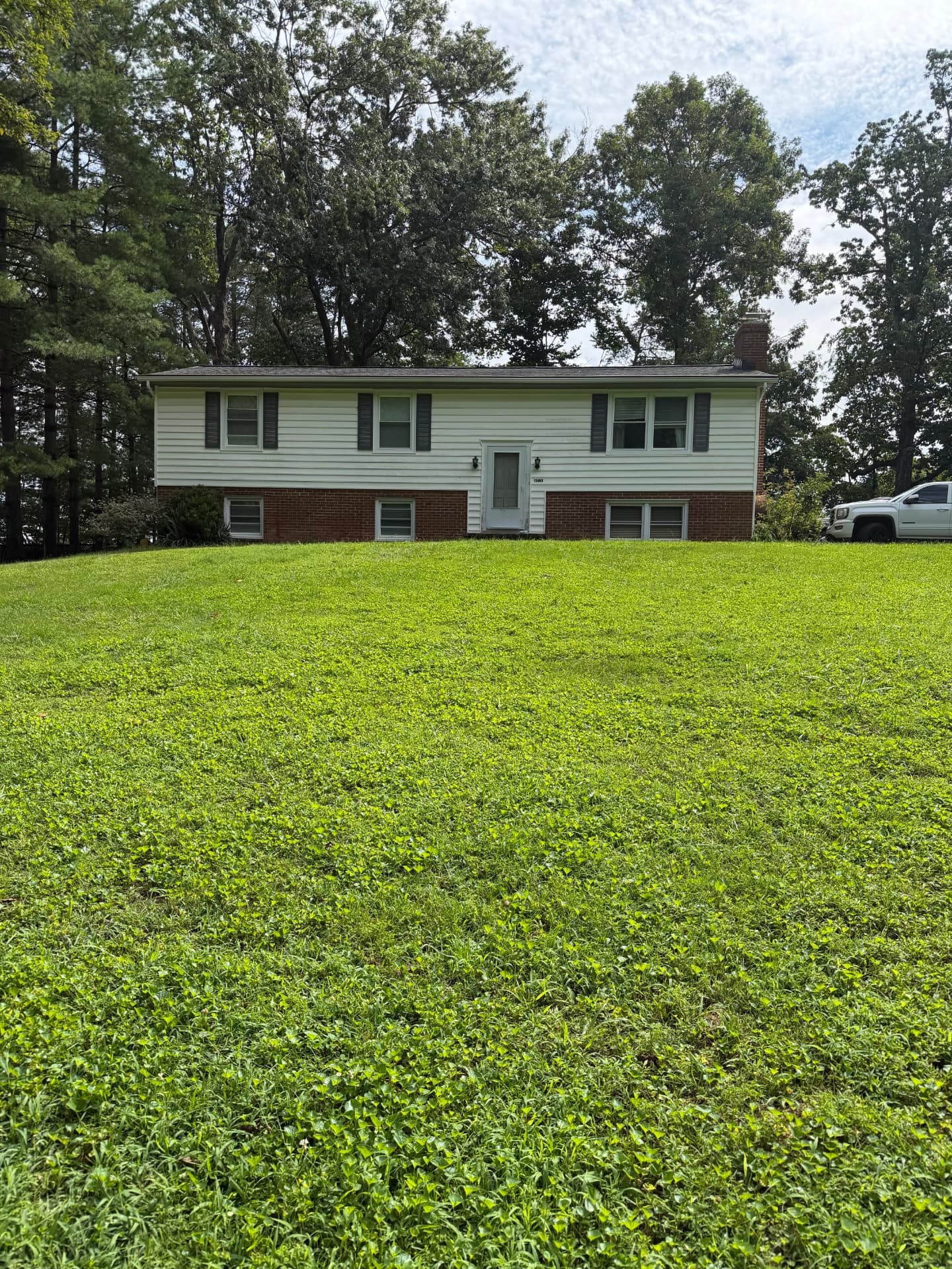 13483 Carapace Ct, Manassas, Virginia — split-level home with both levels visible on a 1.02-acre wooded lot
